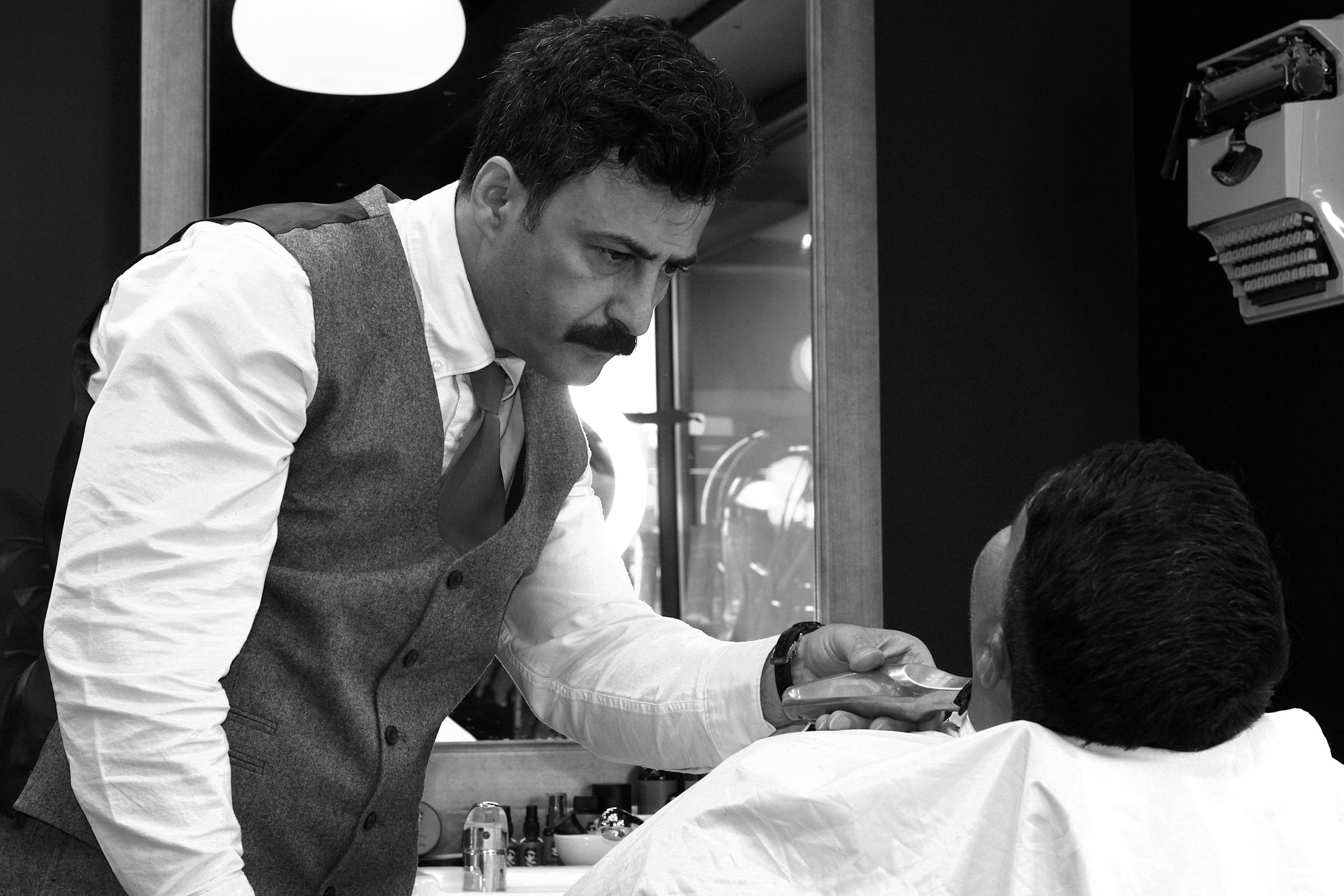 HAIRETRO barber trimming a client's beard with precision