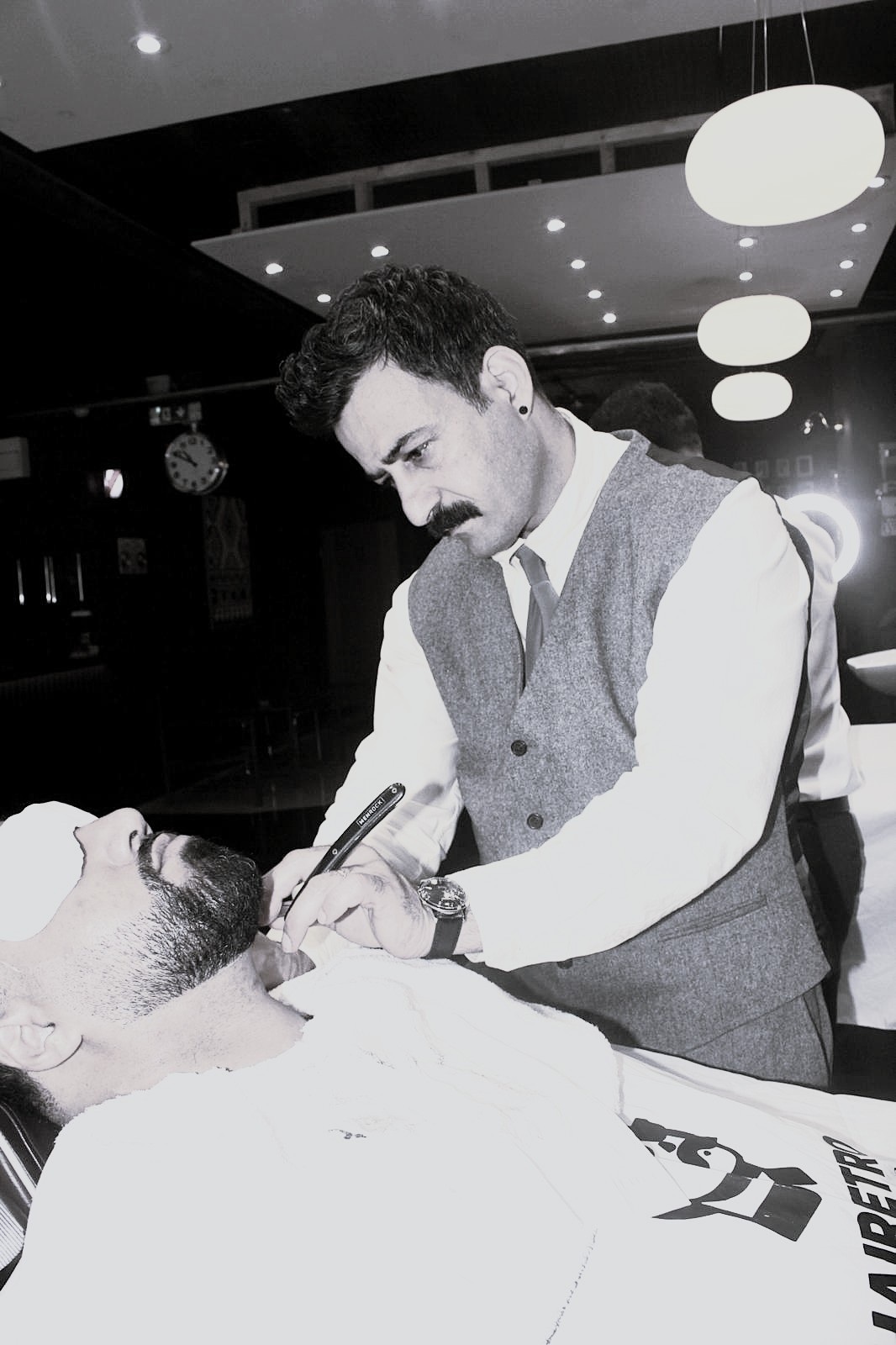 HAIRETRO barber trimming a client, mirror reflection showing the shop
